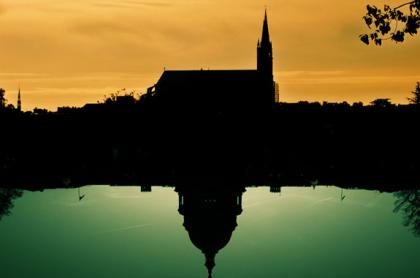 A church reflected in a still pond at dawn